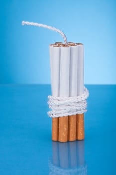 Cigarettes Tied With Rope And Wick Over Blue Background
