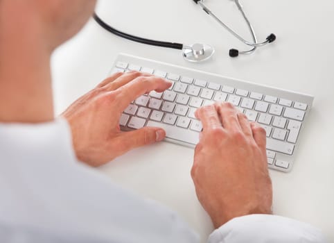 Close-up Of A Male Doctor Typing On Keyboard