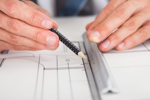 Close-up Of Person's Hand Drawing Plan On Blue Print