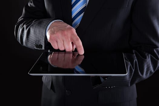 Close-up Of Businessman Using Digital Tablet On Black Background