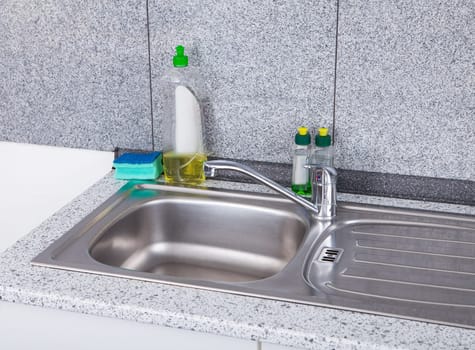 Dishwashing Liquid With Sponge On Silver Kitchen Sink