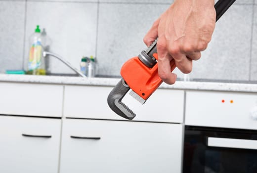 Close-up Of Wrench And Kitchen In Background