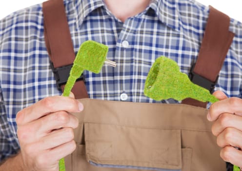 Close-up Of Architect Holding Grass Covered Electric Plug And Socket