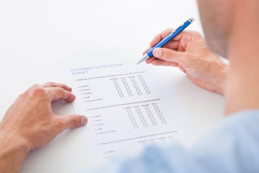 Close-up Of A Person Filling Survey Form With Pen