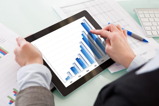 Businessperson Analyzing Graph On Digital Tablet In The Office