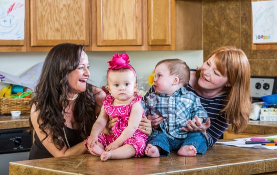 Mothers in kitchen pose with their babies