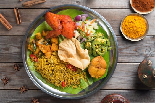 Overhead view of full length Indian biryani rice on wooden dining table background.