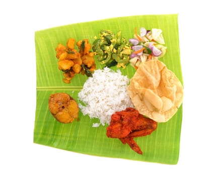Overhead view of full length Indian banana leaf rice isolated on white background.