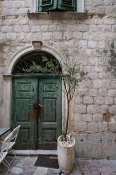 Kotor, July 3, 2021: Beautiful streets in the Old Town of Kotor, green old doors, Montenegro