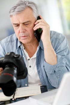 Photographer in office talking on the phone with client