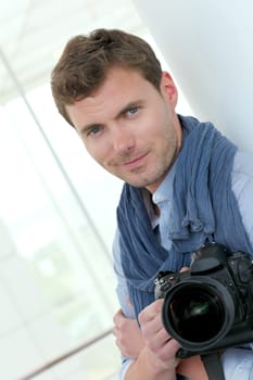 Handsome guy holding photo camera