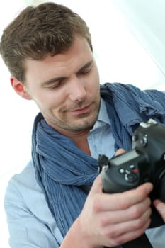 Handsome guy holding photo camera