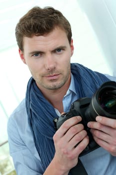 Handsome guy holding photo camera