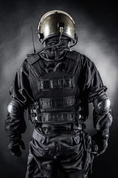 Spec ops soldier on black background shot from behind