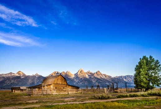 Landscape view of Grand Teton mountain range and abandoned barn, Wyoming, USA