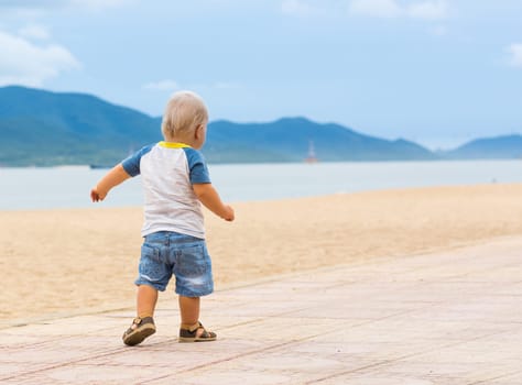 Baby walking along the beach