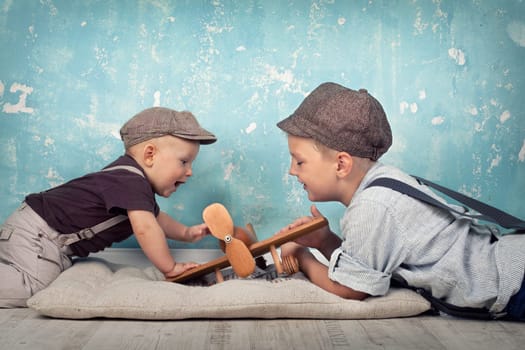 two brothers playing with wooden planes