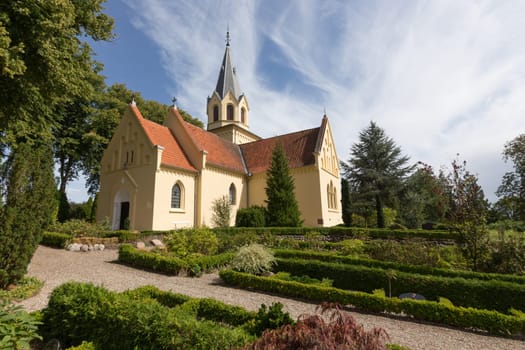 Small yellow church in the cemetery of Tranekér