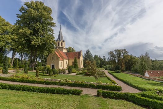 Cemetery with small yellow church in Tranekér
