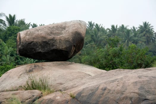 Barrel shaped boulder resting on bed of rock