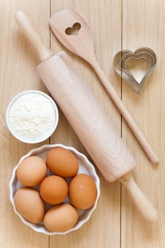 Baking ingredients and baking utensils on wooden substrates