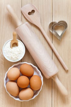 Baking ingredients and baking utensils on wooden substrates