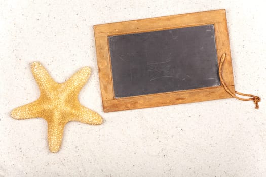 Empty slate with starfish in the sand