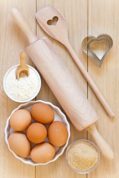 Flour,sugar,eggs and baking utensils on a wooden table