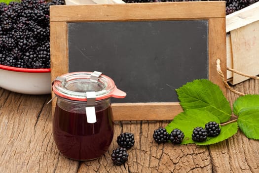 Homemade blackberry jelly and empty slate