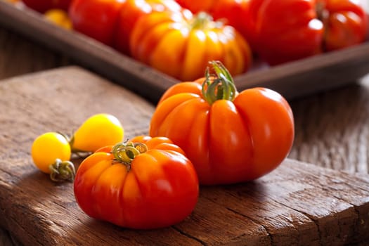 Mature meat tomatoes on old rustic cutting board