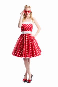 a woman in a dotted dress wears sunglasses