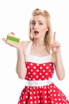 a blonde woman holds a piece of cake and points with her finger