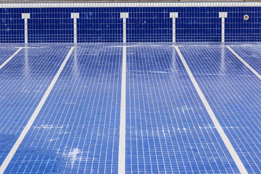 Swimming pool with blue ties and swim lane tile markings empty of water for maintenance