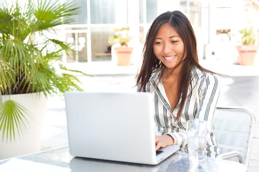 Beautiful asian girl working on her laptop, businesswoman or student