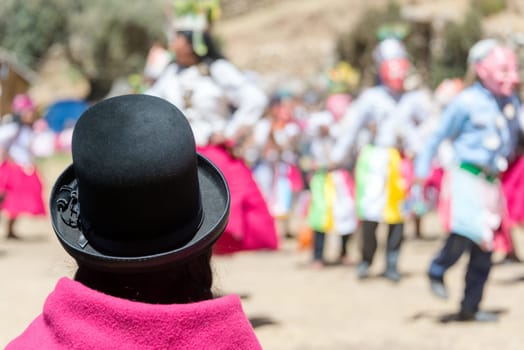Indigenous woman in traditional clothes watching a traditional dance on Island of the Sun on the Bolivian side of Lake Titicaca