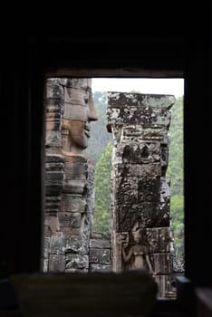 Stone Faces the Tempel Ruin of Angkor Thom in the Temple City of Angkor near the City of Siem Riep in the west of Cambodia.