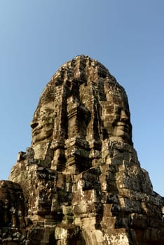 Stone Faces the Tempel Ruin of Angkor Thom in the Temple City of Angkor near the City of Siem Riep in the west of Cambodia.