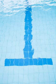 Bottom lane line at end of swimming pool with T-shape slightly distorted by water
