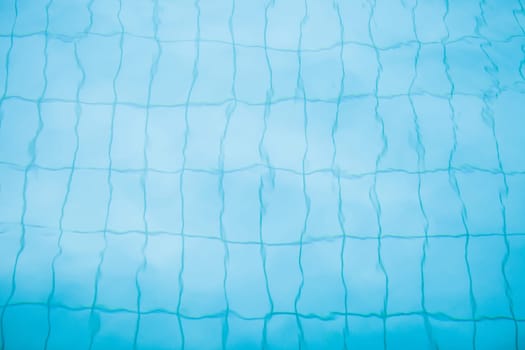 Tiles on bottom of swimming pool distorted slightly by water for background image