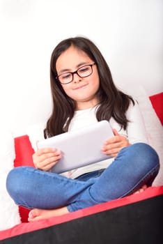 Little cute schoolgirl learning with a Tablet PC at home
