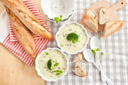 Homemade cream soup with broccoli and fresh baguette