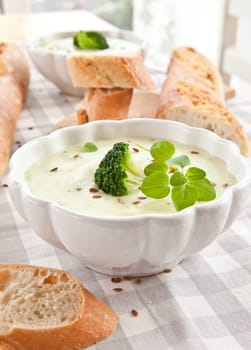 Homemade cream soup with broccoli and fresh baguette