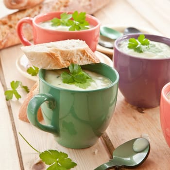 Homemade cream soup with broccoli and fresh baguette
