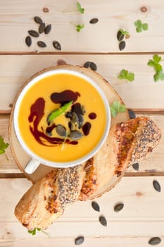 Homemade kuerbis soup in cup with stick