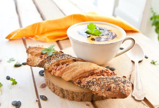 Homemade kuerbis soup in cup with stick
