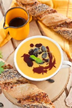 Homemade kuerbis soup in cup with stick