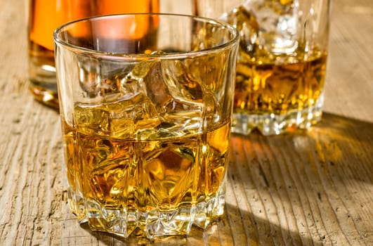 Two tumblers with whisky and bottle