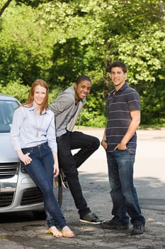 Three young friends with a car