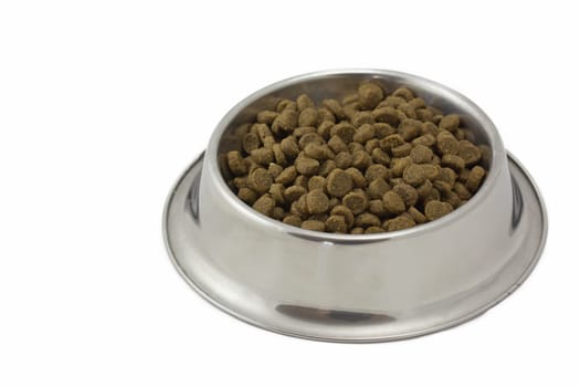 Dry food for dogs in a metal bowl. Isolated on a white background.