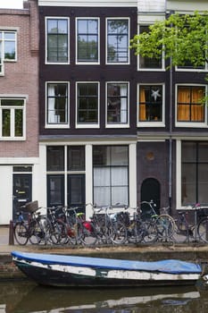 Traditional Dutch houses along the canal. (Amsterdam, Netherlands). Vertically. All potential trademarks are removed.